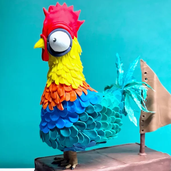 une patisserie unique à genève en 3 dimensions pour homme et femme avec garniture vanille et parfum fraise fait par Natcake et représentant le coq HeiHei du film Moana