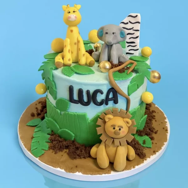 Gâteau jungle personnalisé avec animaux en pâte à sucre : lion, éléphant, girafe. Cake sur mesure pour anniversaire enfant, thème safari. Pâtisserie artisanale Genève et Lausanne.